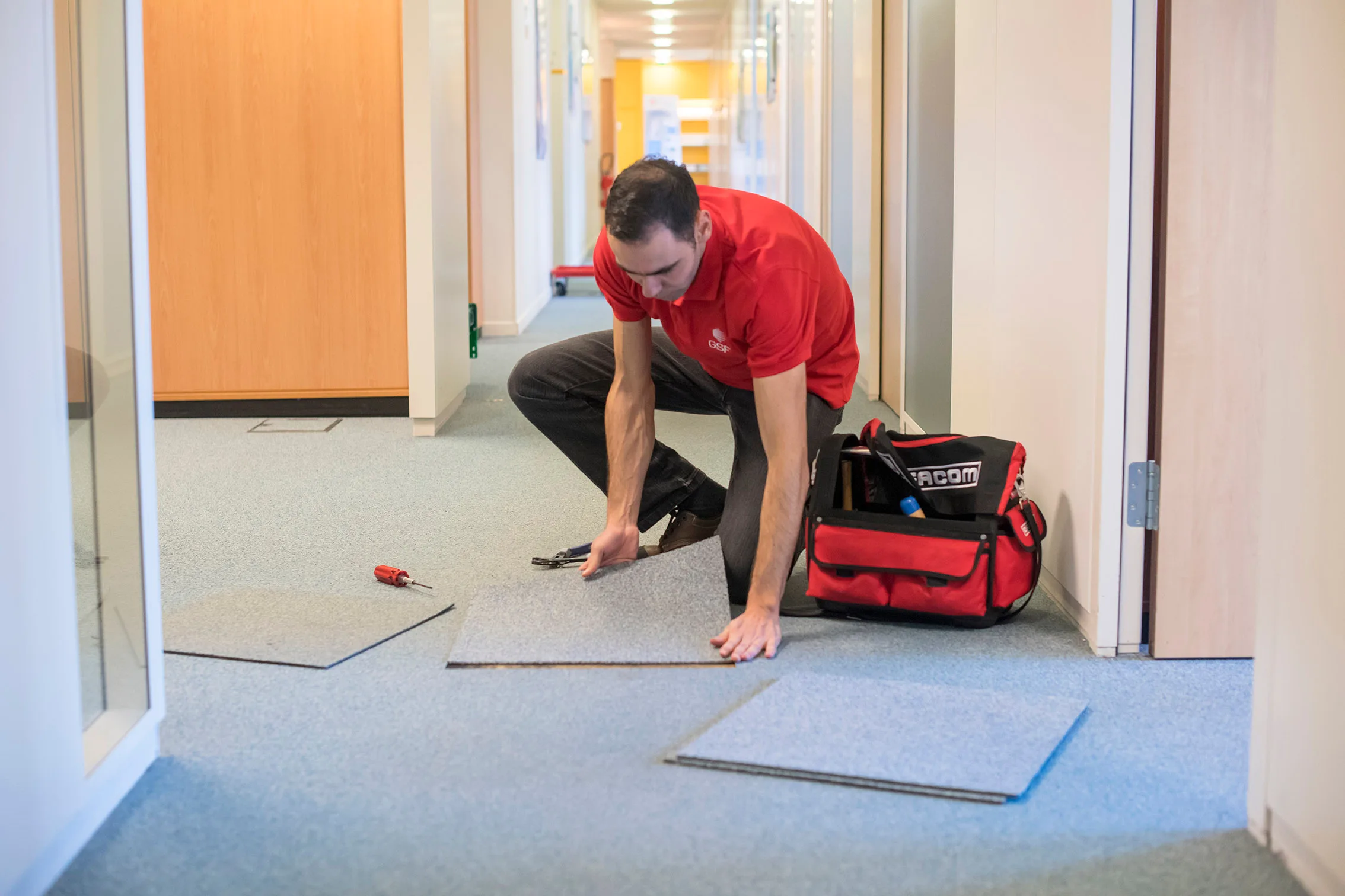 Intervention technique sur un plancher surélevé dans un corridor.